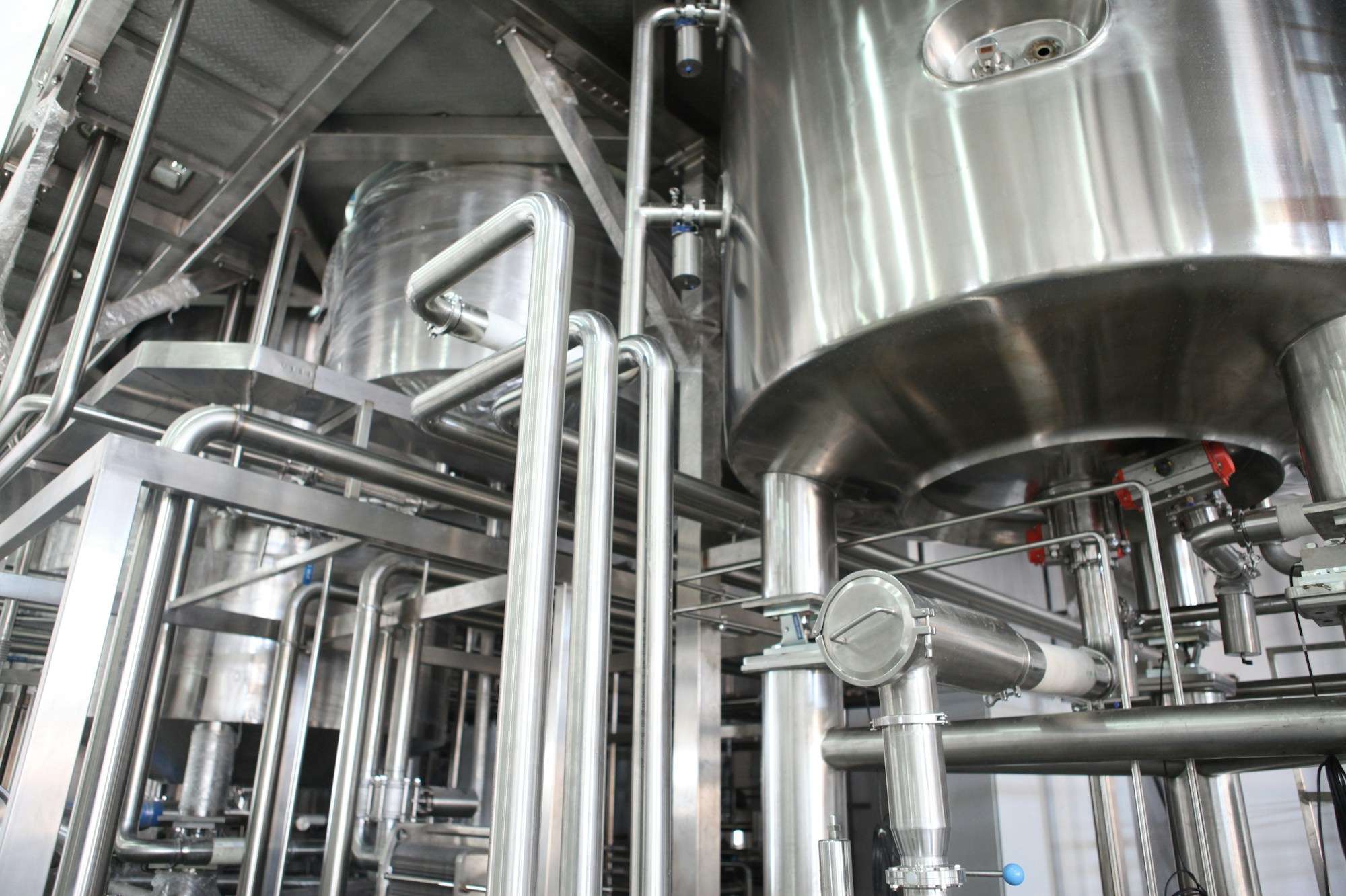 Stainless steel process tanks and pipework in a food and beverage production area