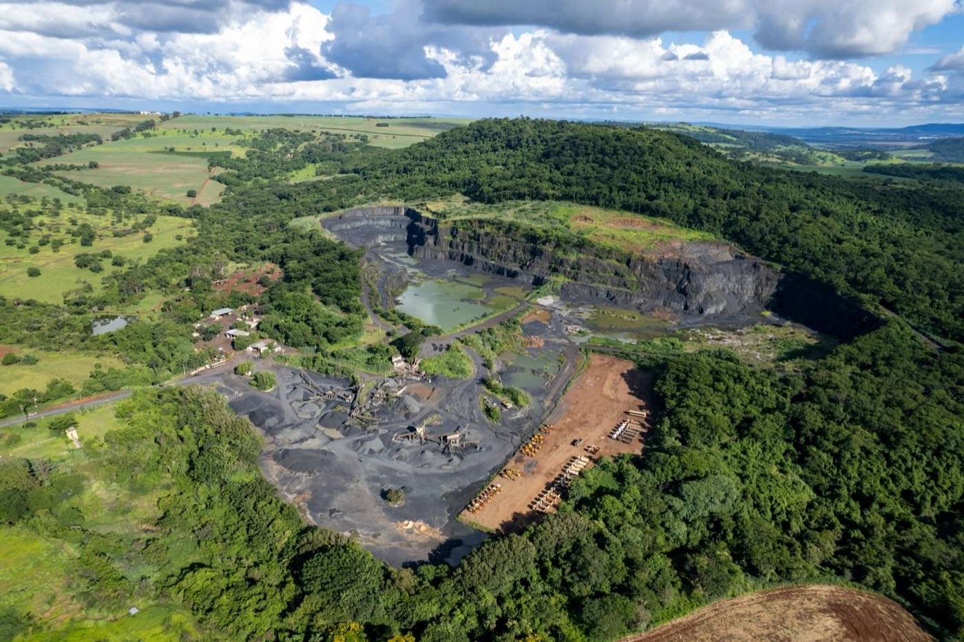 Aerial view of a quarry pit surrounded by bush and farmland
