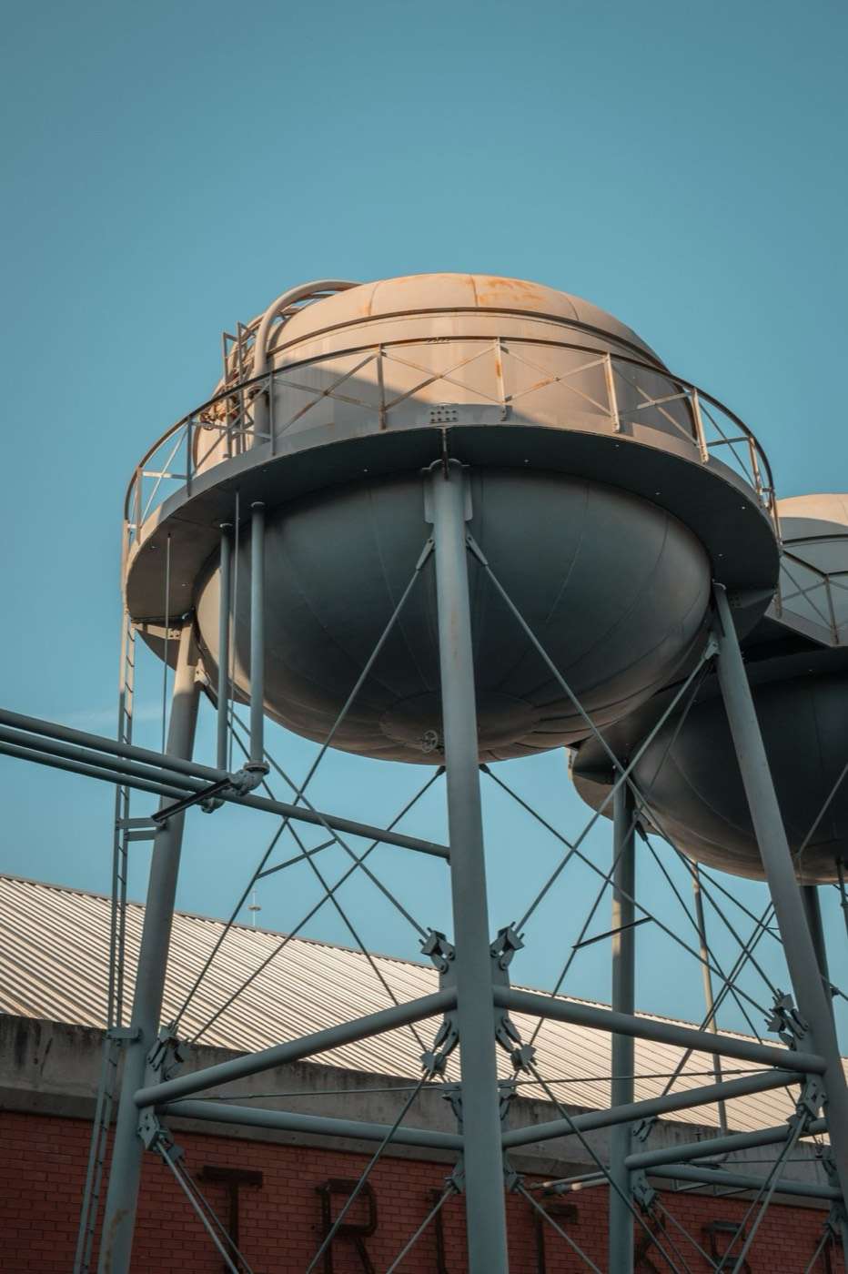 Steel legs and tank of a water tower seen from below